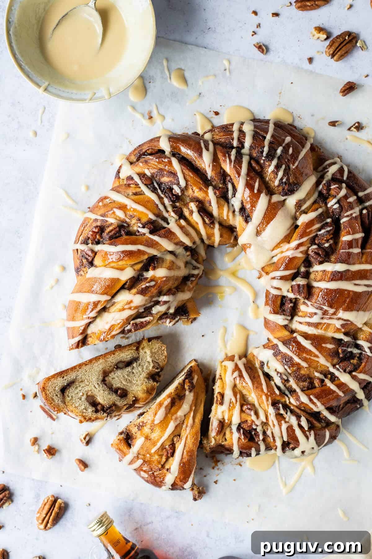 Maple pecan bread wreath – this impressive vegan maple pecan couronne is a real showstopper which would be perfect for an indulgent breakfast or brunch. #veganbaking #eggless #dairyfree #bread #veganbreakfast #veganbrunch Close up of vegan maple pecan bread wreath with two slices cut out.