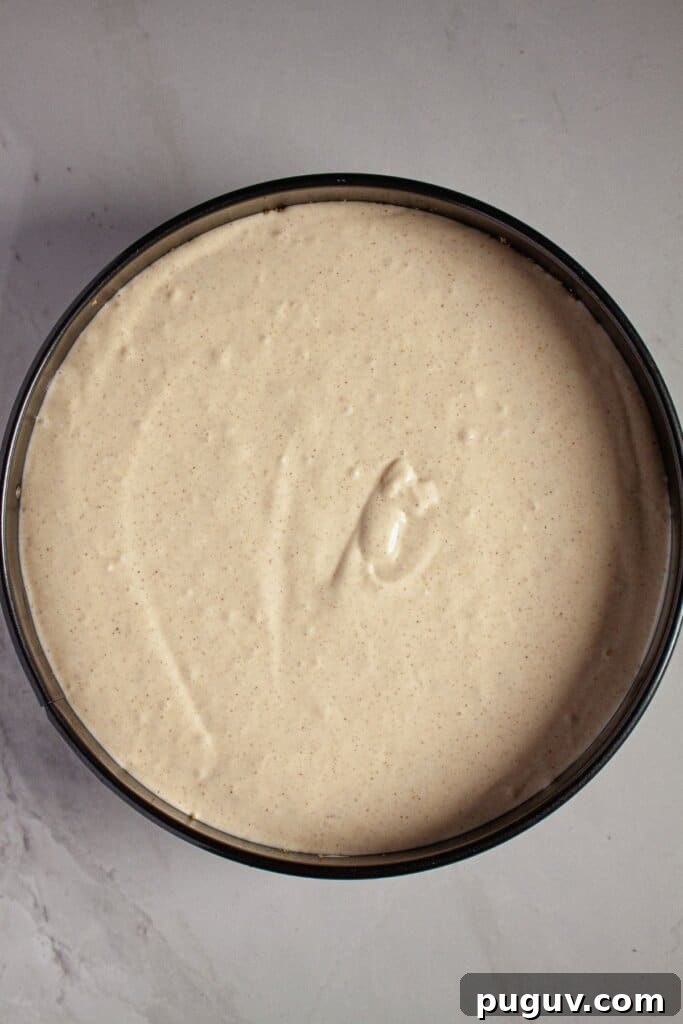 Decadent RumChata Cheesecake Recipe: Creamy Liqueur Dessert 8 Batter poured into a springform pan ready for the oven.
