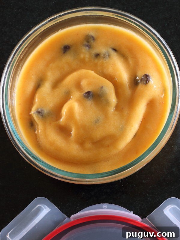 Peach dairy-free sorbet with chocolate chips in a round Pyrex bowl with snap on lid