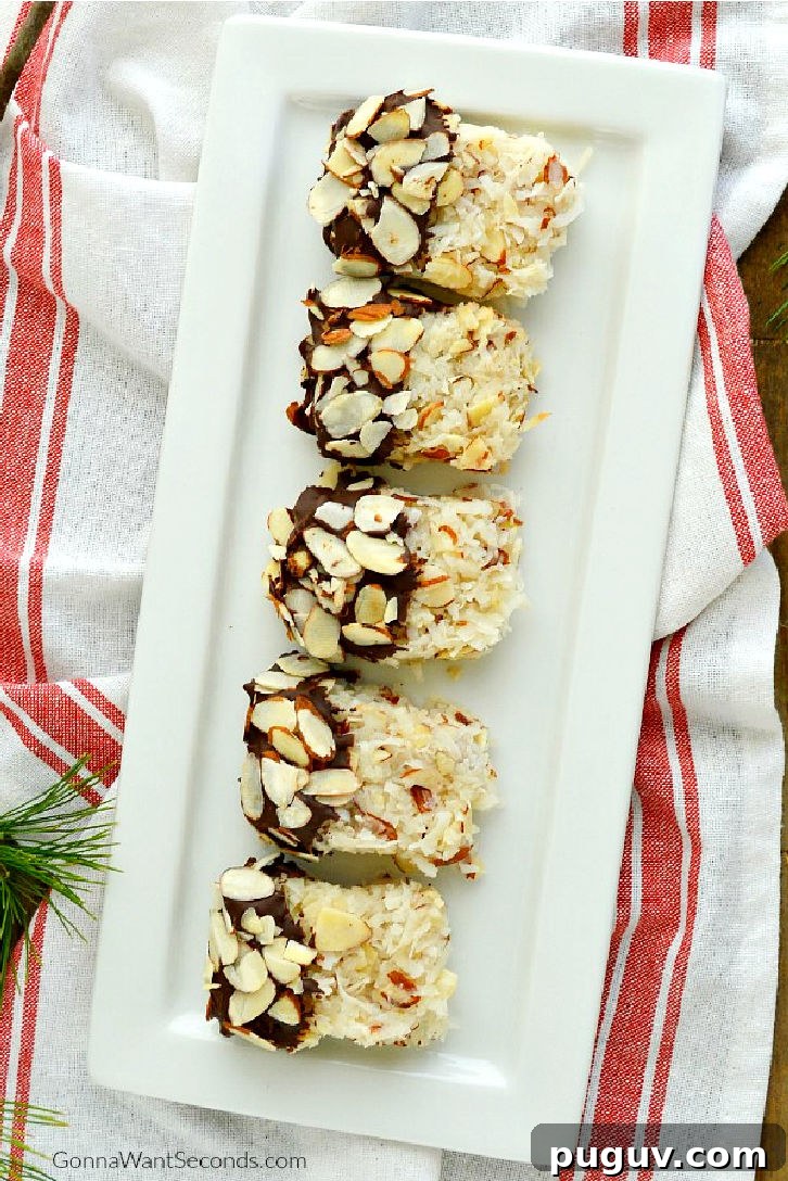 These Coconut Almond Macaroons are sheer perfection! Ooey Gooey and moist, loaded with coconut, dipped in chocolate, and sprinkled with sliced almonds. Chocolate Dipped Coconut Almond Macaroons on a serving platter