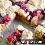 Apple Butter Cherry Cobbler Bars - These cherry cobbler bars have added depth of flavor with a secret ingredient. Simple and sweet with cherry pie filling and the great, unique taste of Musselman's Apple Butter.