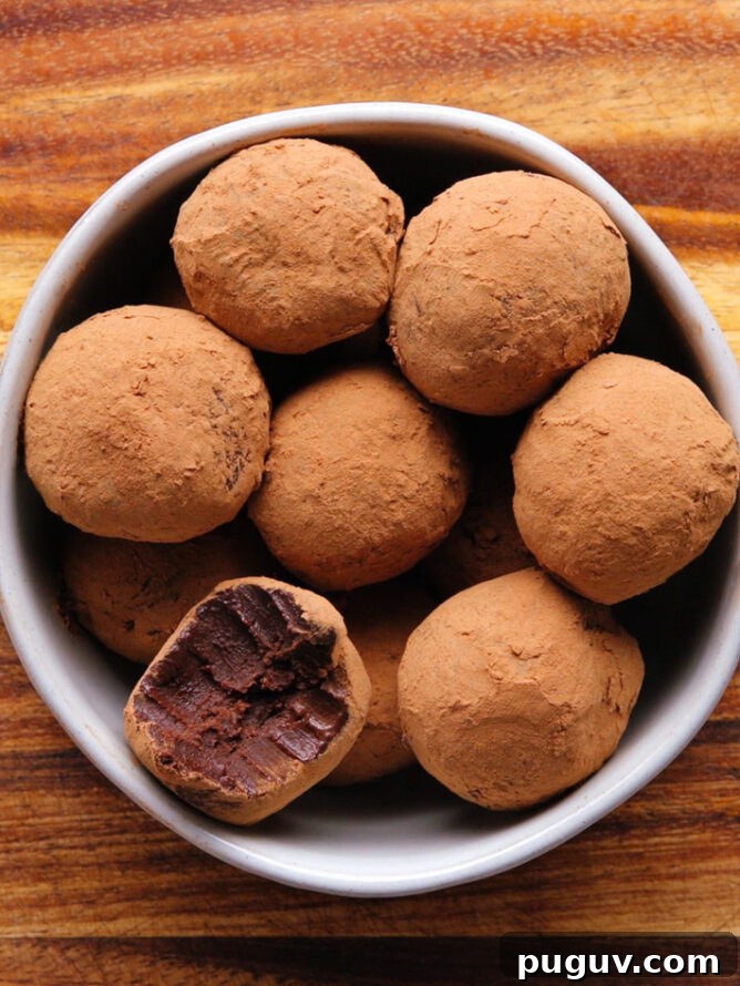 chocolate truffles rolled in cocoa powder, bite taken out