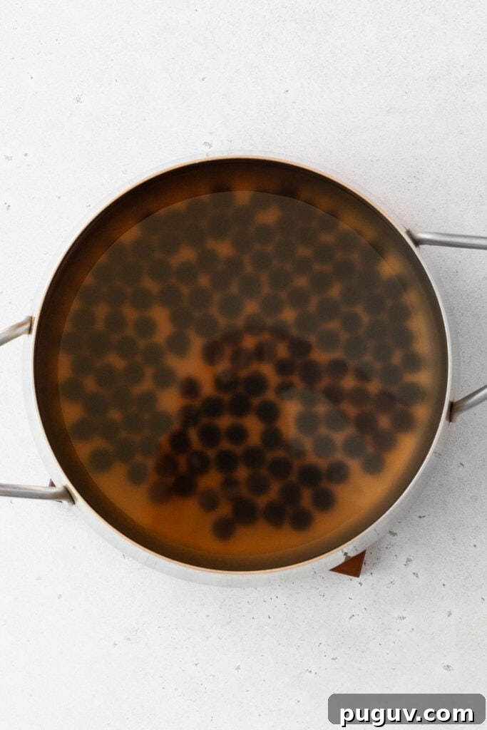 Cooking boba pearls in a large pot.