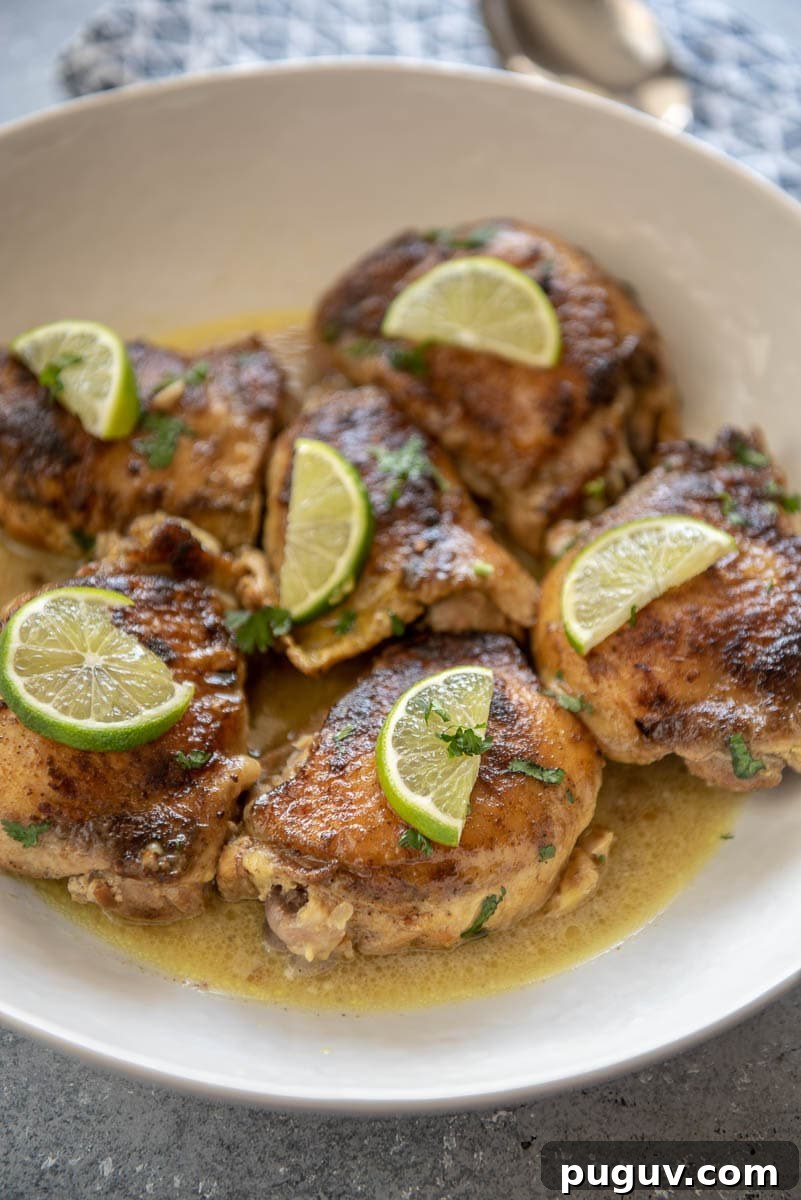 Coconut Lime Slow-Cooker Chicken with Garlic and Cilantro 5 white bowl filled with coconut lime chicken thighs topped with lime wedges
