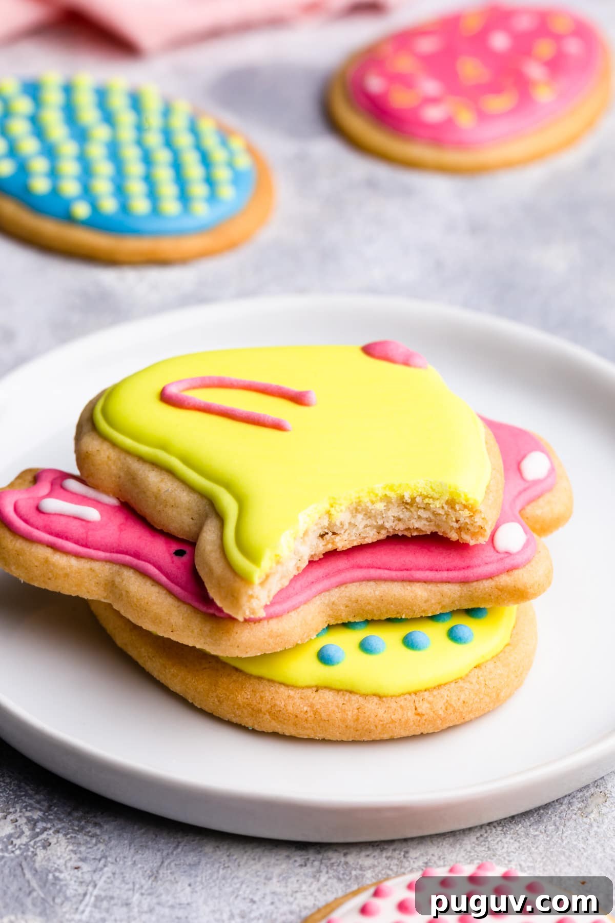 Easter Sugar Cookie Recipe with Simple Decorative Icing 9 side close up at stack of sugar cookies with top one missing a bite