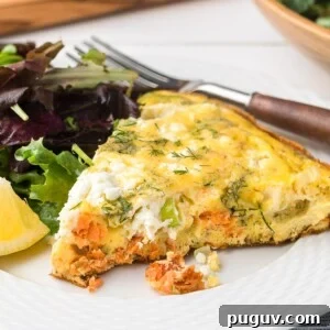Smoked Salmon, Leek & Goat Cheese Frittata Recipe 10 wedge of smoked salmon and goat cheese frittata on a white plate with spring greens, a lemon wedge, and a wood and stainless steel fork