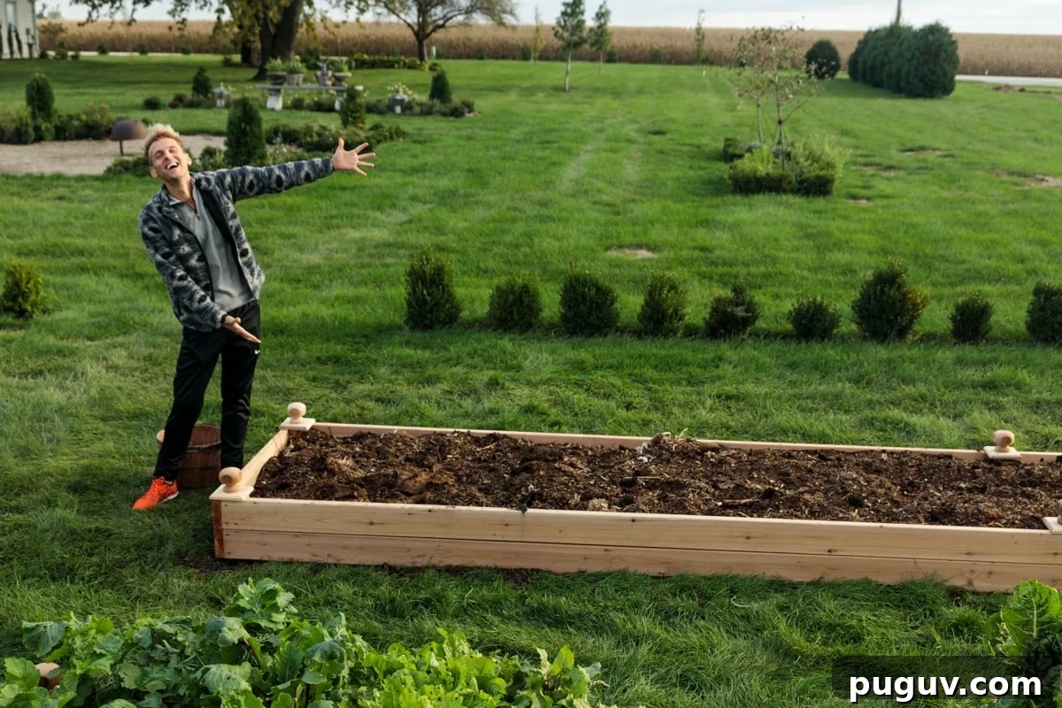 Build Raised Garden Beds: A Step-by-Step Guide for Any Yard 2 Man with blonde hair standing beside completed raised garden bed filled with dark brown soil with grass all around