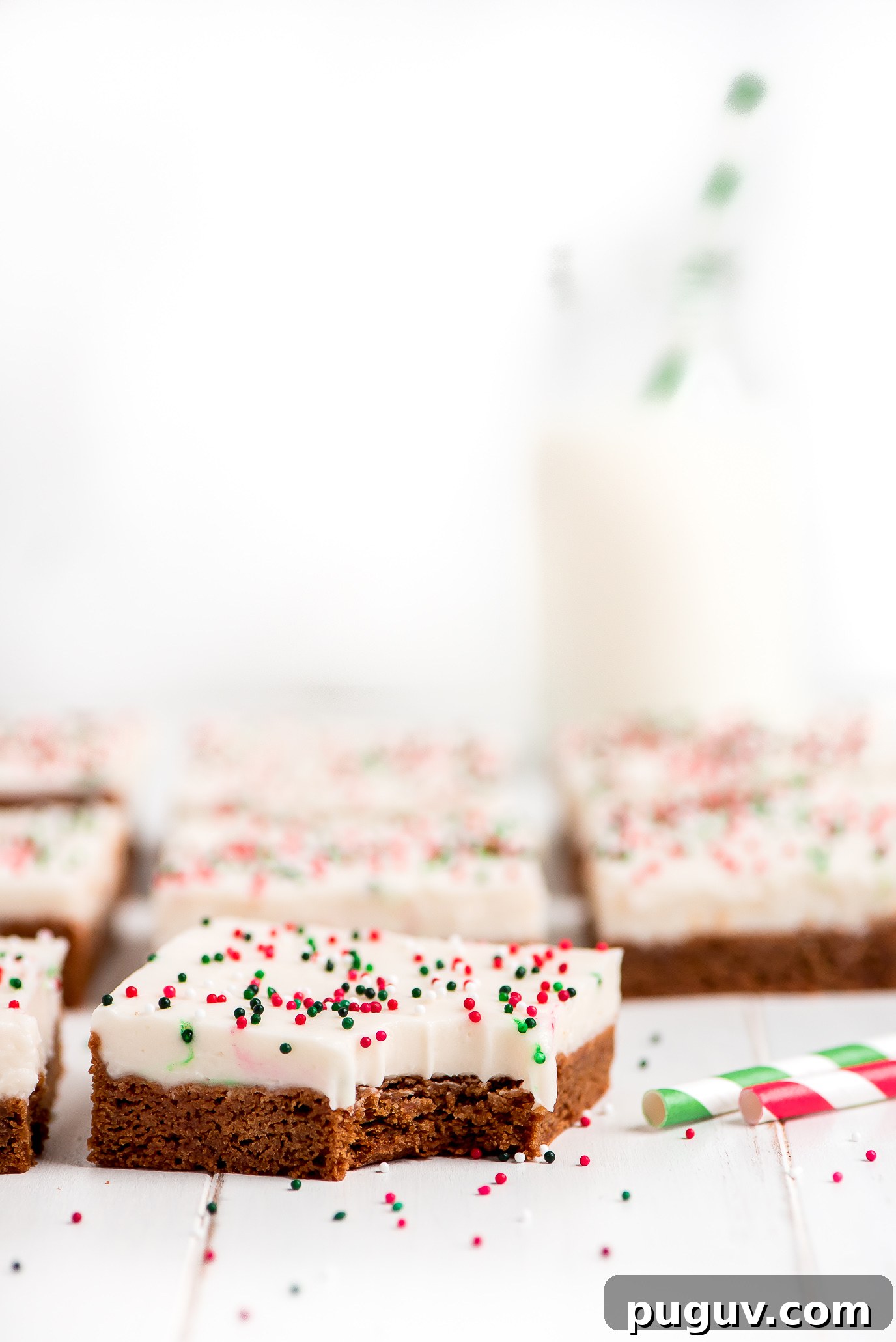 Gingerbread Sugar Cookie Bars topped with cream cheese frosting. Gingerbread Sugar Cookie Bars frosted with cream cheese frosting and sprinkled with red, white, and green sprinkles.