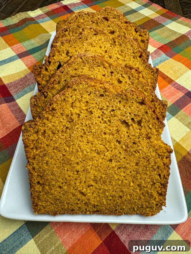 Moist Pumpkin Spice Quick Bread Recipe for Fall Baking 3 Slices of a copycat recipe for Bob Evans Pumpkin Bread laying on a white tray on an autumn colored plaid napkin.
