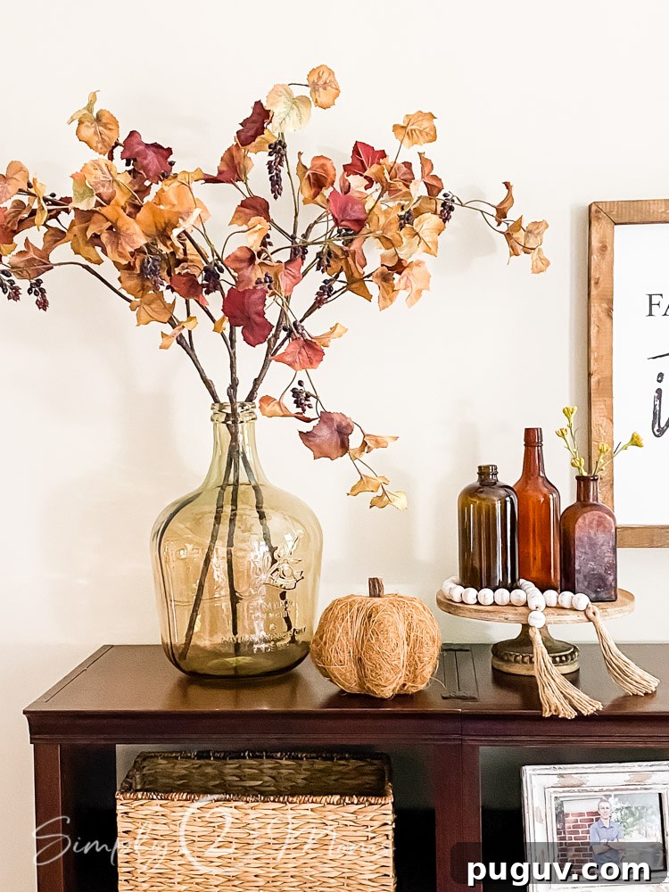 13 Stunning Ways to Add Fall Color to Your Home 8 amber vintage glass bottles with fall leaves and vase