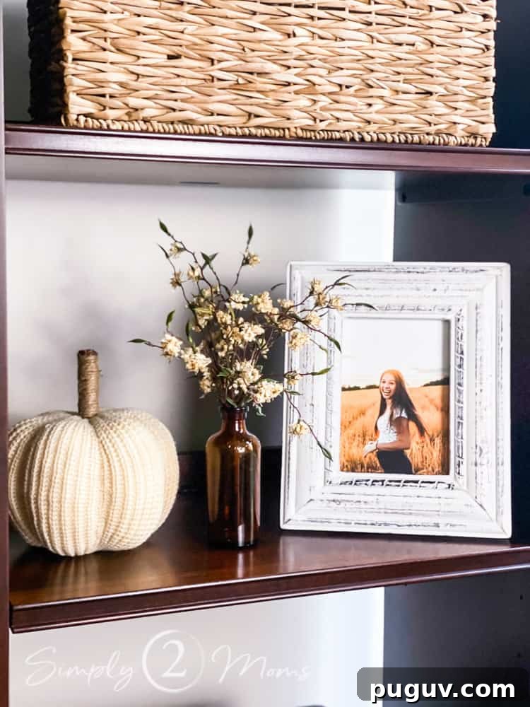 13 Stunning Ways to Add Fall Color to Your Home 20 entertainment center shelf with amber bottle and white sweater pumpkin