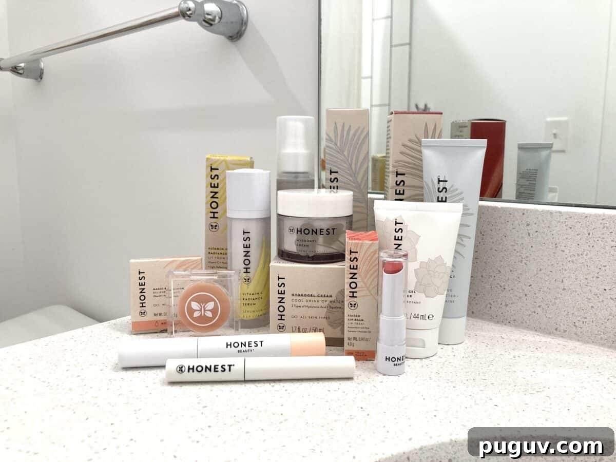 Clean Makeup for Tweens: 8 Safe Brands for Kids and Teens 11 A collection of Honest Beauty skincare and makeup products, including serums, creams, lip color, and mascara, is arranged on a white bathroom counter in front of a mirror.