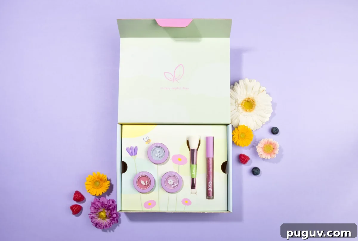 Clean Makeup for Tweens: 8 Safe Brands for Kids and Teens 4 An overhead flat-lay shows an open light-green box containing Jovy's non-toxic makeup set for kids with purple shimmer pots, brushes, and lip gloss, surrounded by fresh flowers and berries on a lavender background.