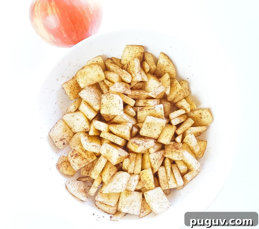 a bowl of sliced apples tossed with cinnamon and sugar