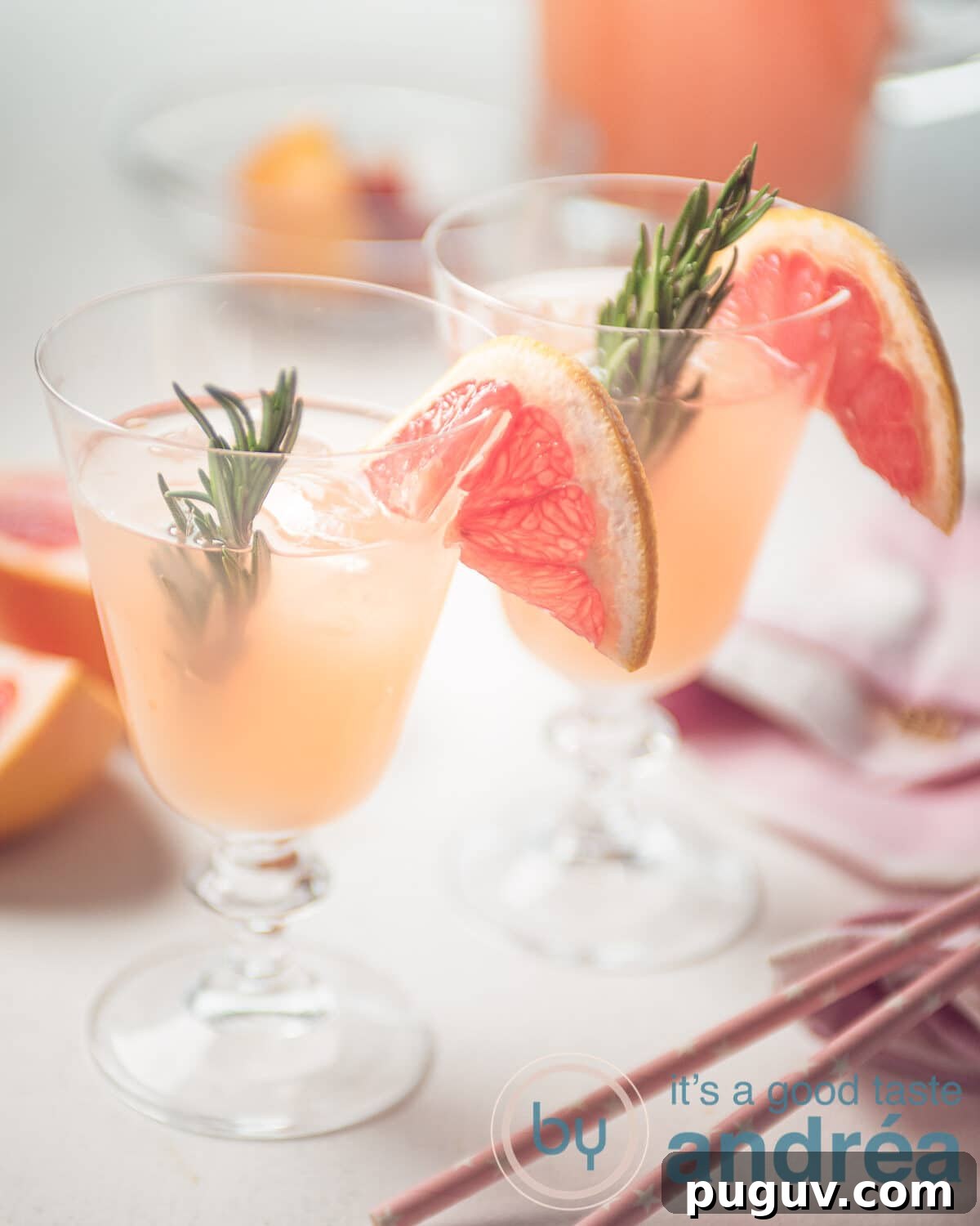 Two grapefruit mocktails with rosemary and straws