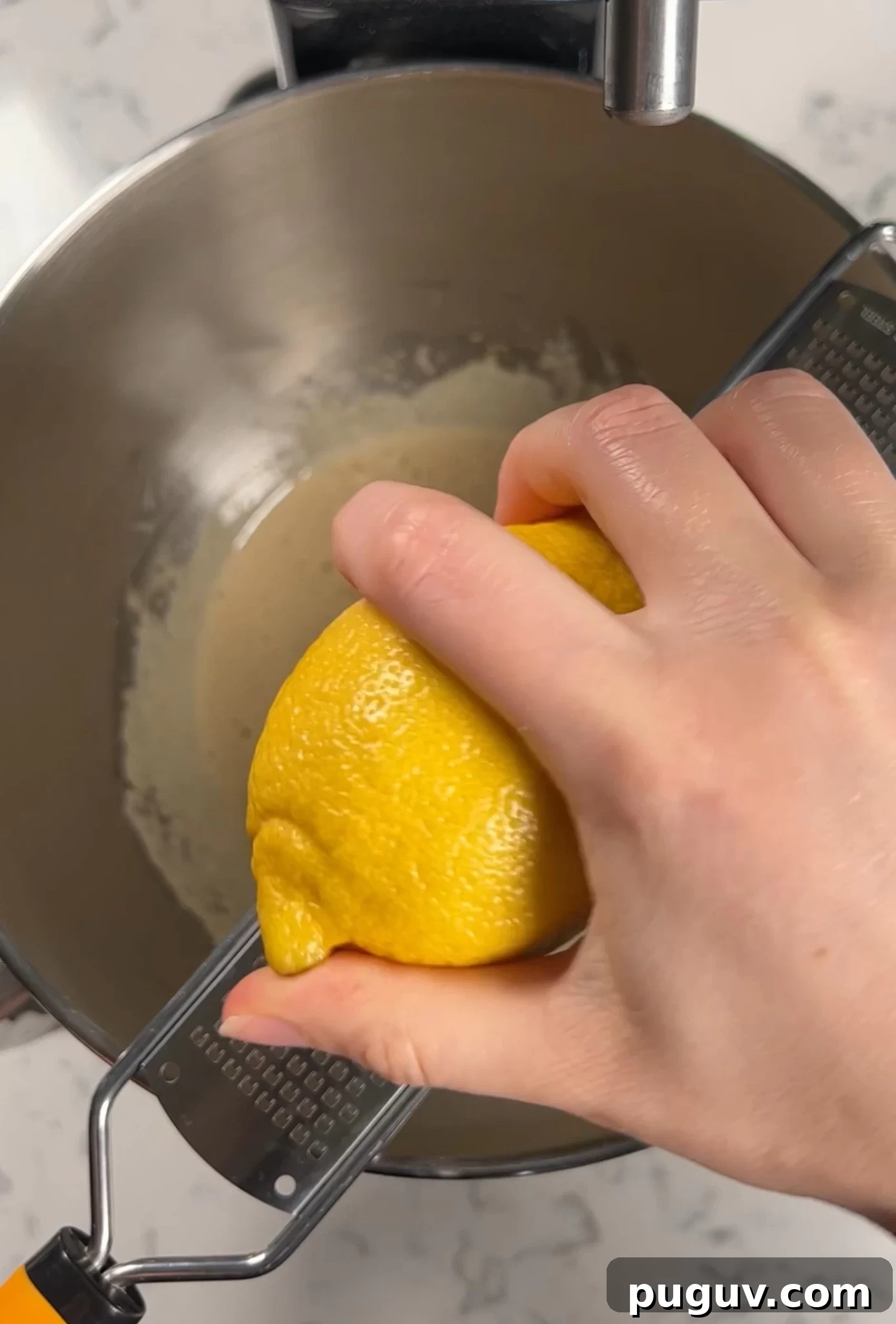 Adding lemon zest to the cake batter.