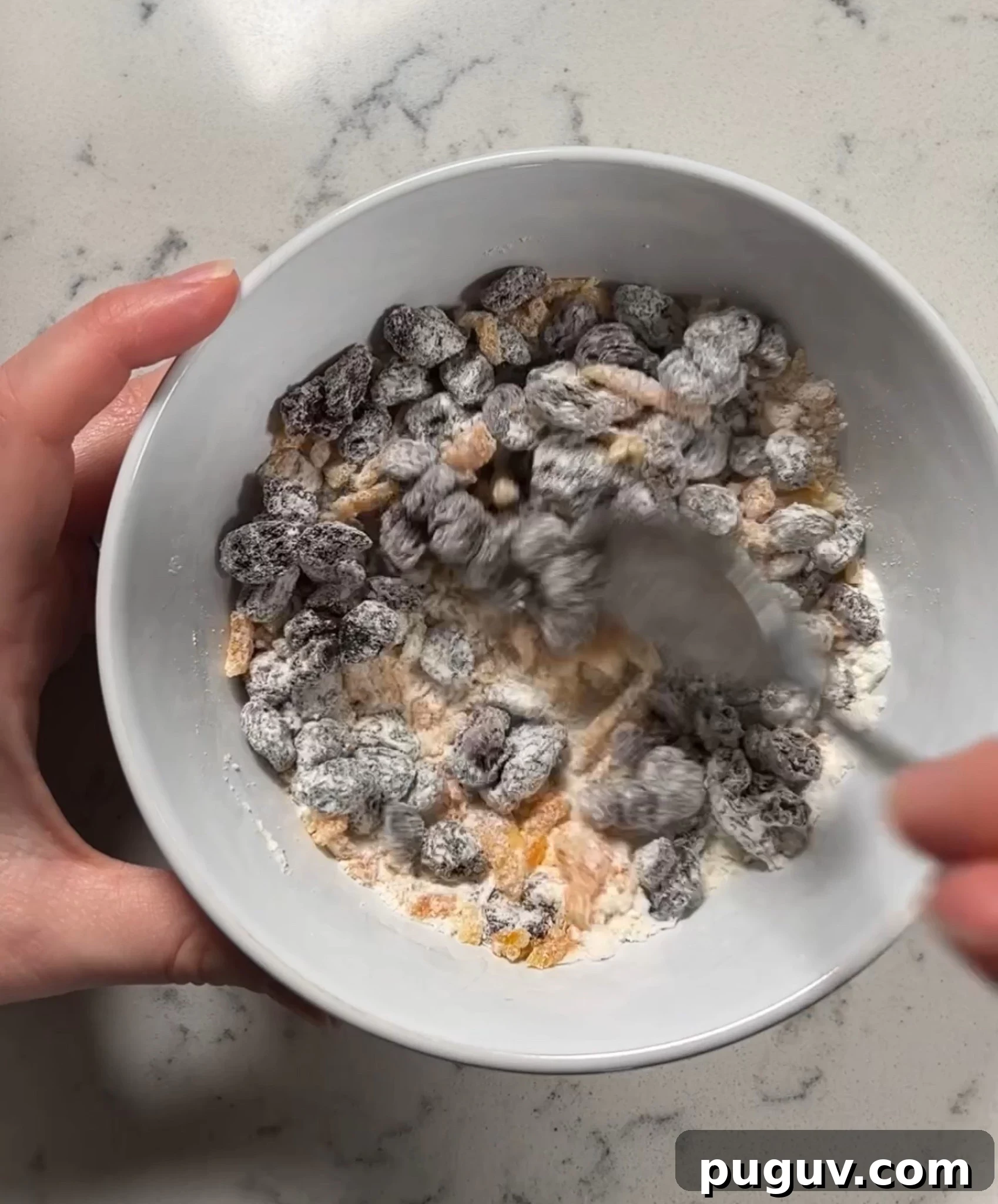 Adding flour to the raisins and orange peel.