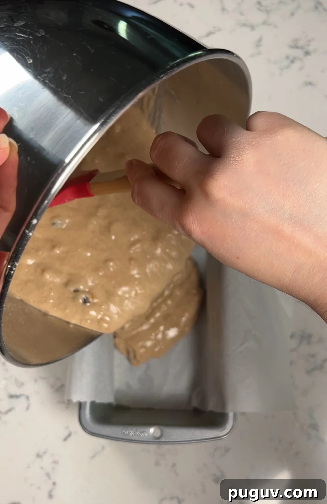 Adding the cake batter to a loaf pan.