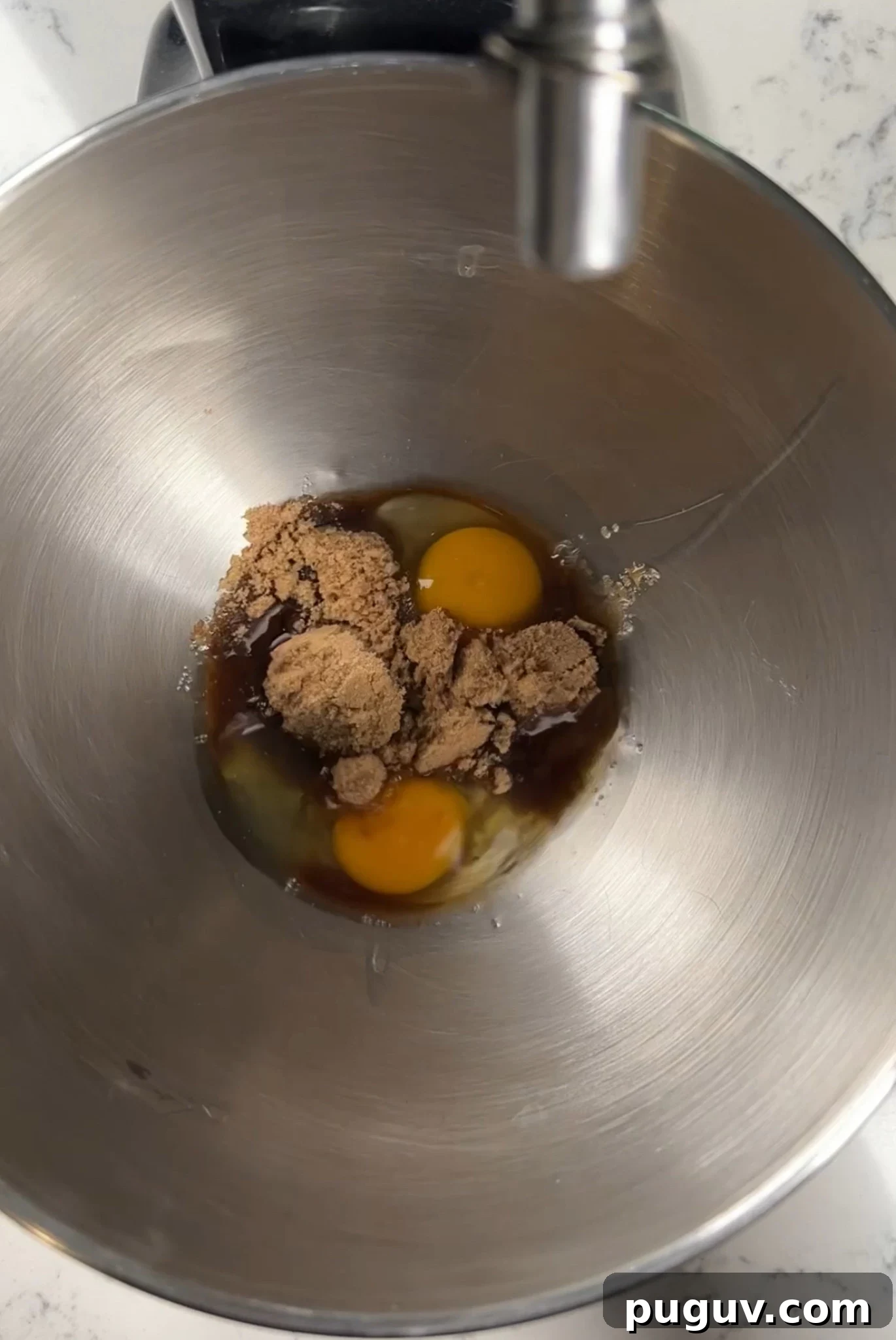 Eggs and sugar in a mixing bowl.