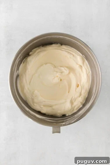 whipped cream in a bowl on a white surface.