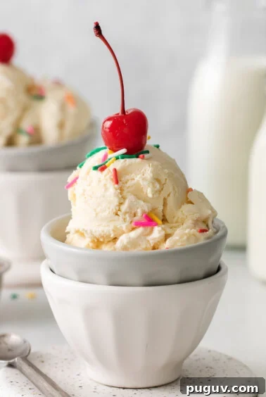 two bowls of ice cream with cherries and sprinkles.