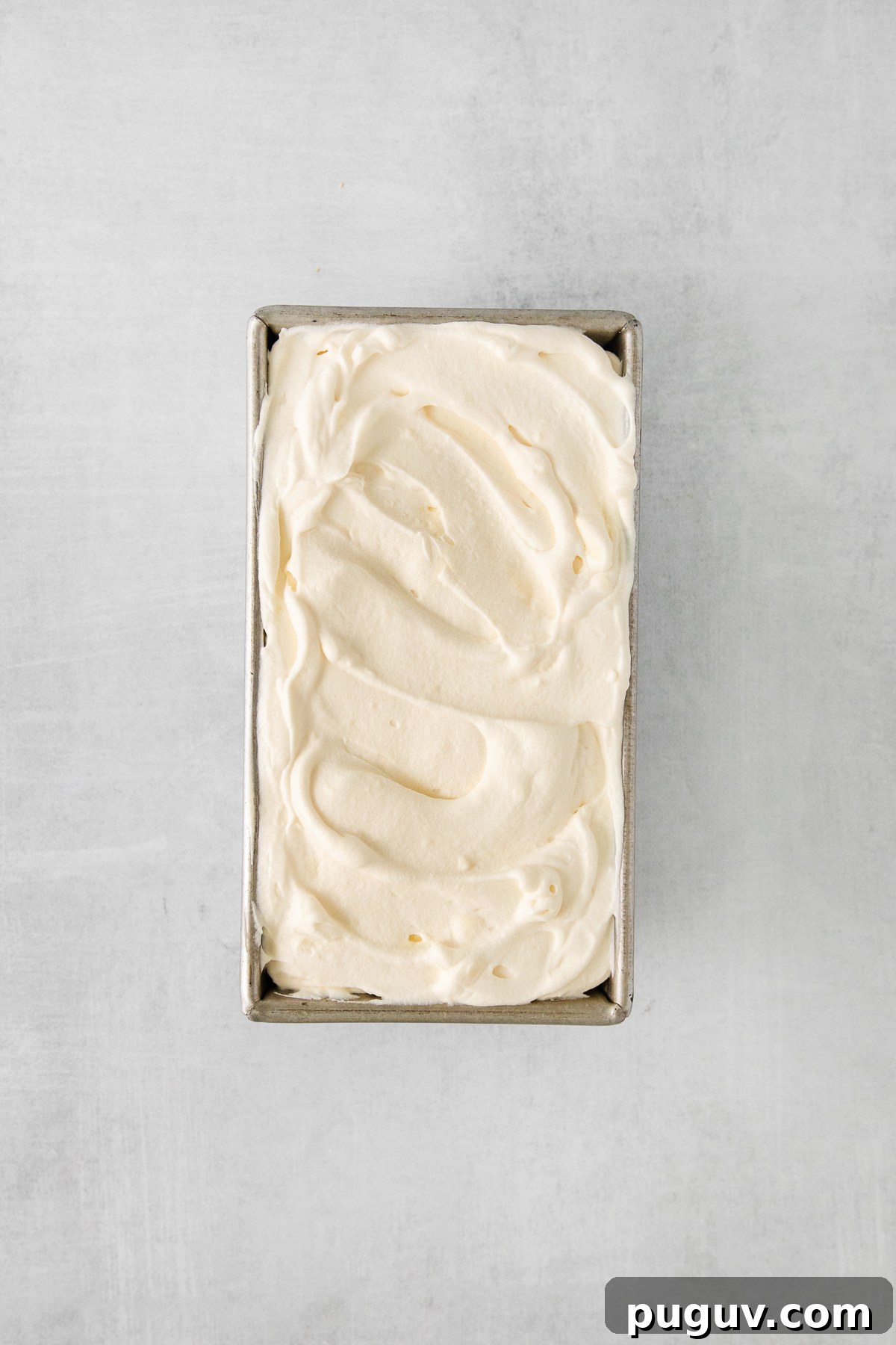 whipped cream in a metal box on a grey background.