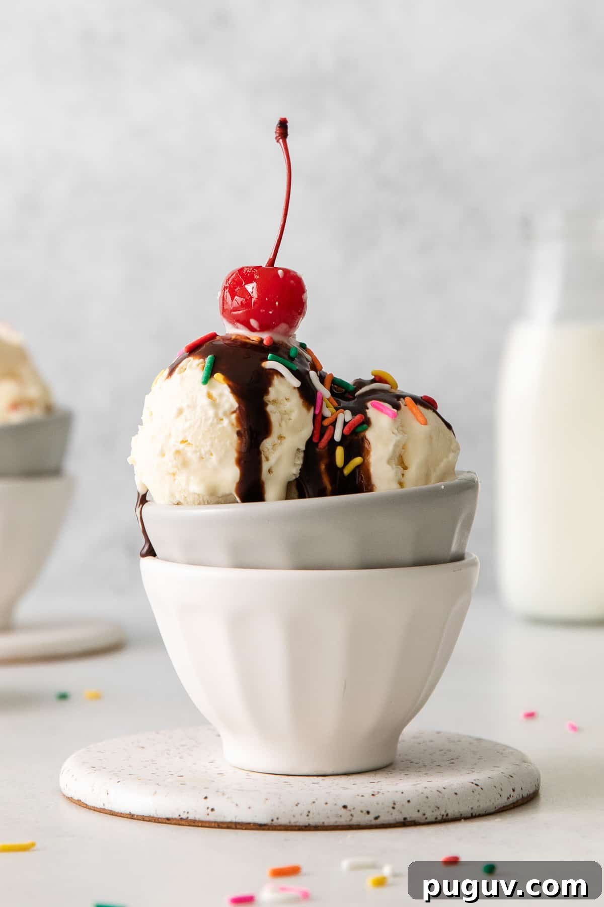two bowls of ice cream with a cherry on top.