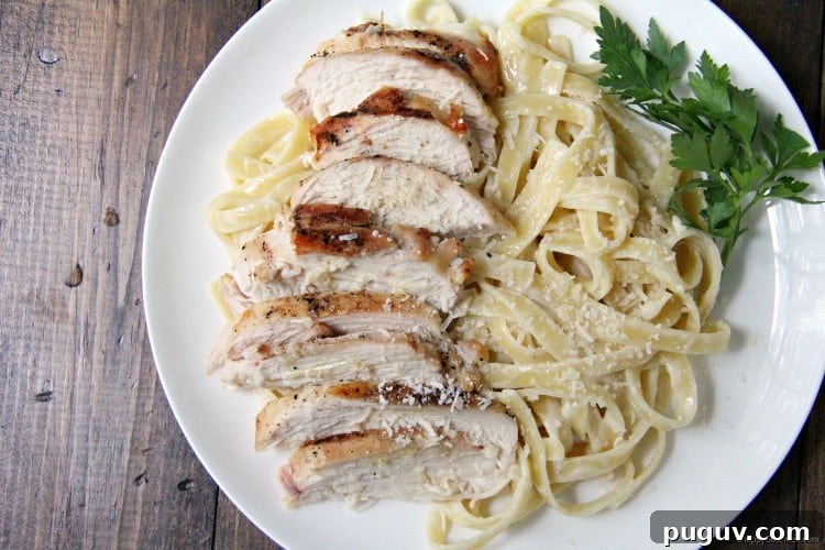 fettuccine alfredo with from scratch alfredo sauce and grilled chicken slices on plate