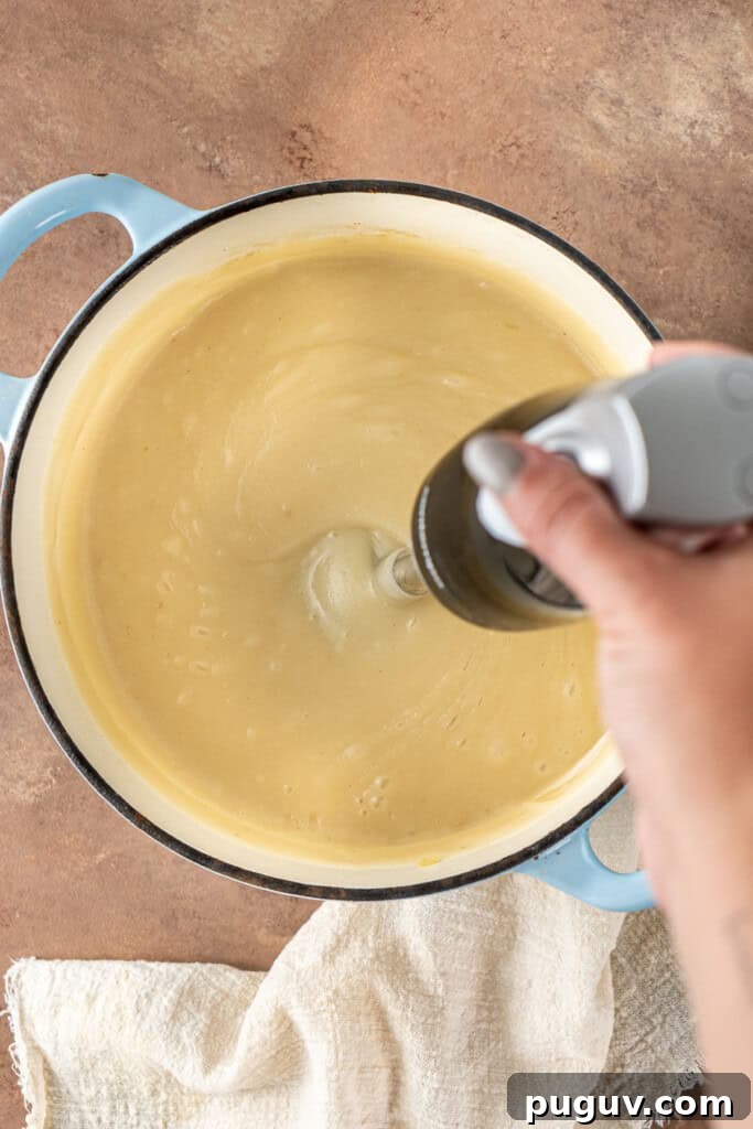 Creamy Dairy-Free Baked Potato Soup Recipe 8 Using a stick blender to blend the potato soup in the pot.