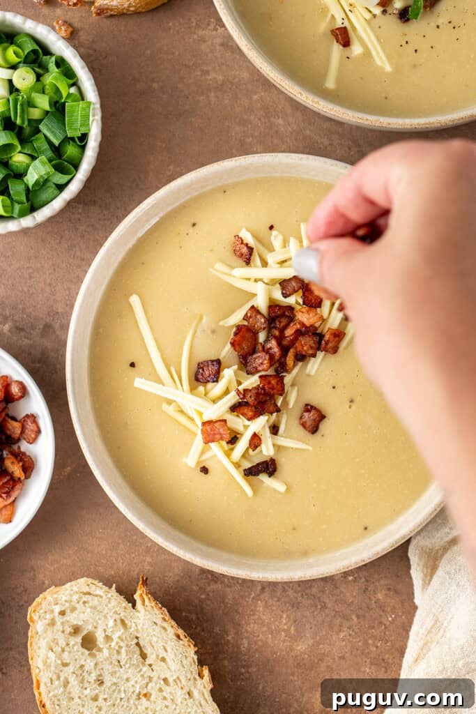 Creamy Dairy-Free Baked Potato Soup Recipe 10 Sprinkling bacon pieces over the soup.