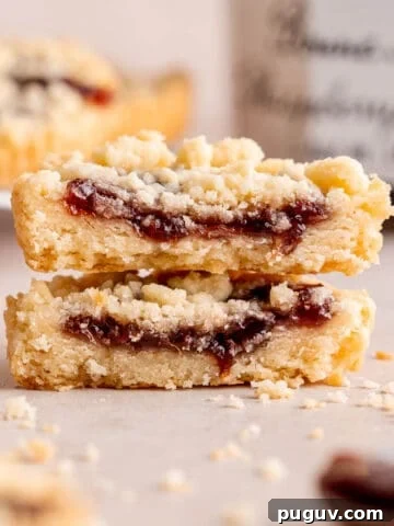Two halves of a raspberry crumble cookie stacked on top of each other.