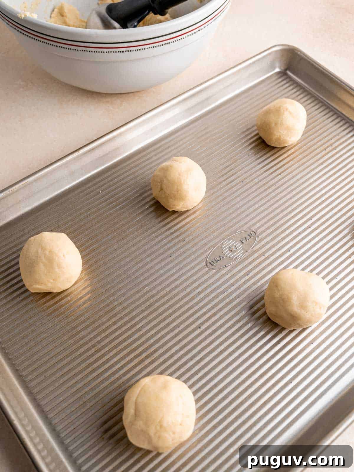 Soft Almond Sugar Cookies with Melt-In-Your-Mouth Texture 7 Almond sugar cookie dough balls on a baking sheet.
