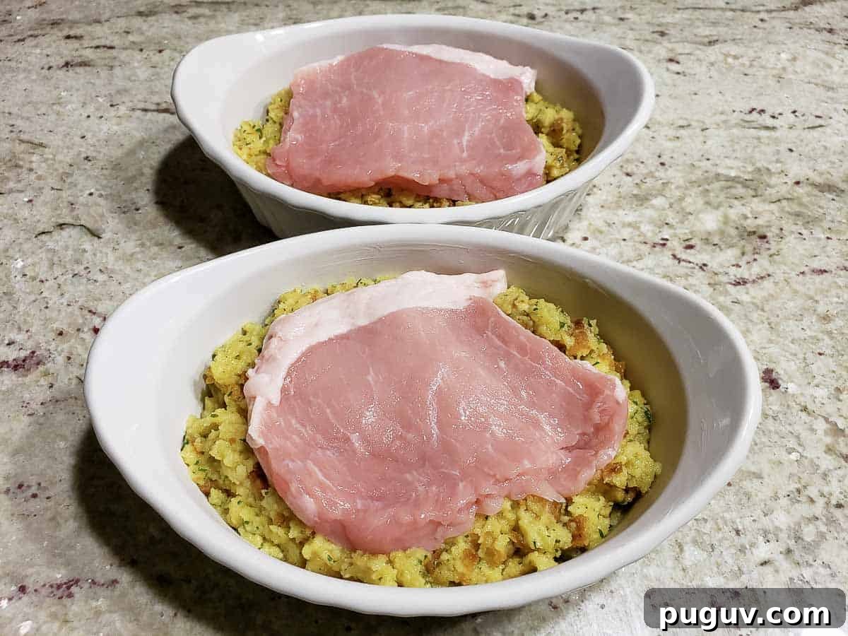 a pork chop layered over stuffing in two casserole baking dishes.