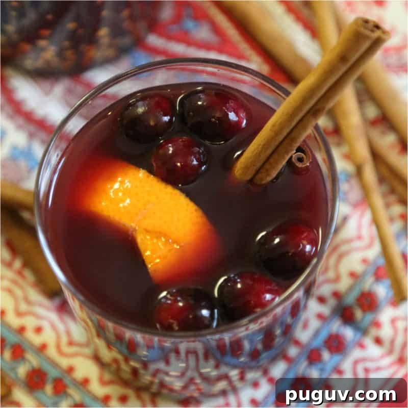 Christmas Cocktail Recipes Everyone Will Love 3 mulled white with an orange slice, cranberries, and cinnamon stick