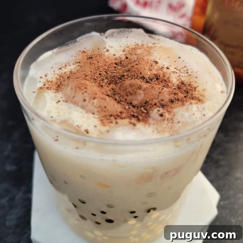 Christmas Cocktail Recipes Everyone Will Love 21 Amaretto Eggnog Cocktail in a gold polka dot glass on a white coaster