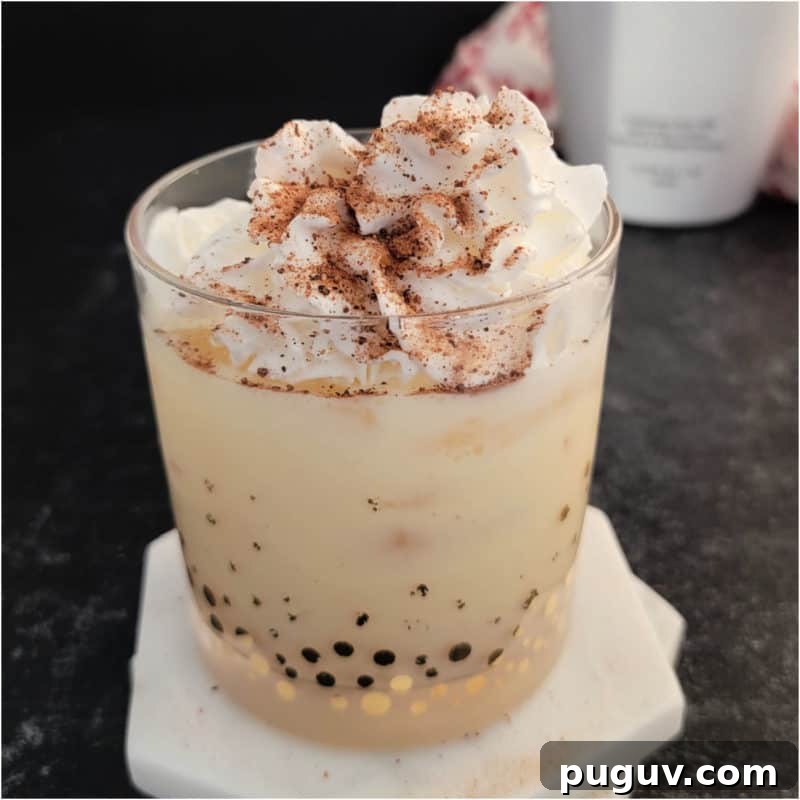 Christmas Cocktail Recipes Everyone Will Love 25 RumChata Eggnog Cocktail garnished with whip cream and nutmeg on white coasters