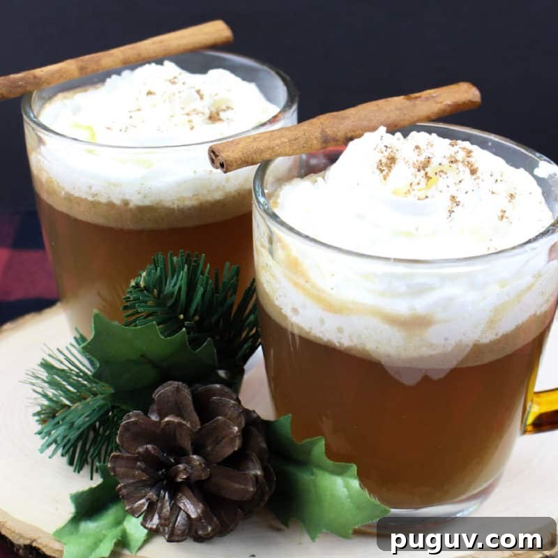 Christmas Cocktail Recipes Everyone Will Love 4 Hot Buttered Rum in glass coffee mugs with cinnamon sticks on a wood board