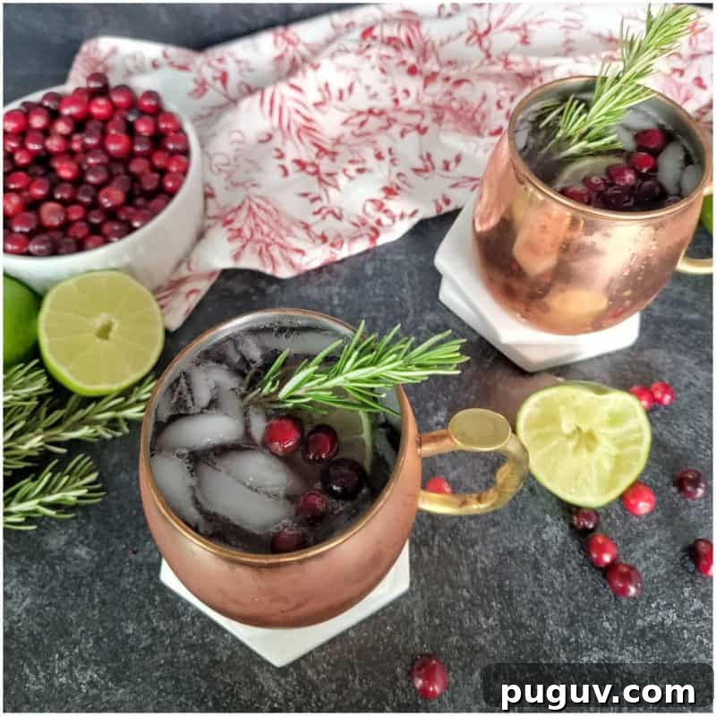 Christmas Cocktail Recipes Everyone Will Love 6 cranberry mules in copper mugs with a bowl of cranberries and lime slices