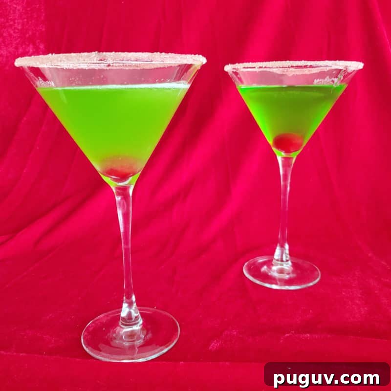 Christmas Cocktail Recipes Everyone Will Love 8 Two Bright green cocktails with cherries in them in martini glasses with a sugared rim.