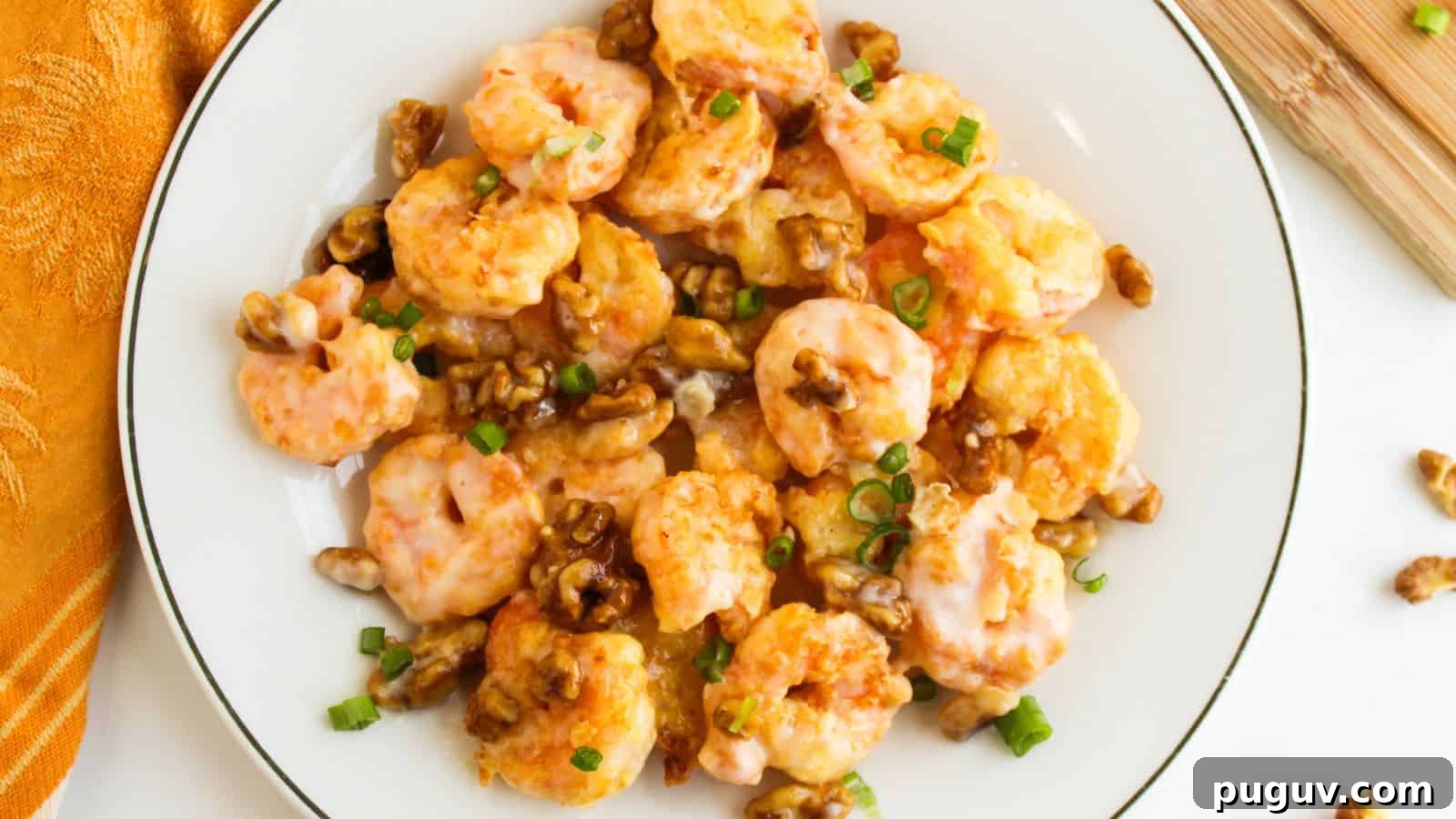 15 Chinese Dishes That Let You Cook Dinner in 30 Minutes 3 A plate of honey walnut shrimp topped with green onions.