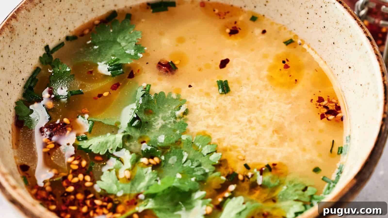 15 Chinese Dishes That Let You Cook Dinner in 30 Minutes 4 A comforting bowl of egg drop soup elegantly garnished with fresh cilantro, vibrant chives, and a sprinkle of chili flakes.