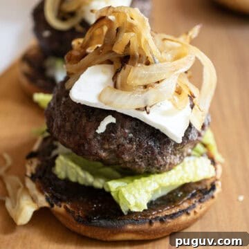 Fig Jam & Goat Cheese Burger Recipe for Sweet Savory Flavor 7 The burger on a bed of lettuce over fig jam, topped with goat cheese and caramelized onions.