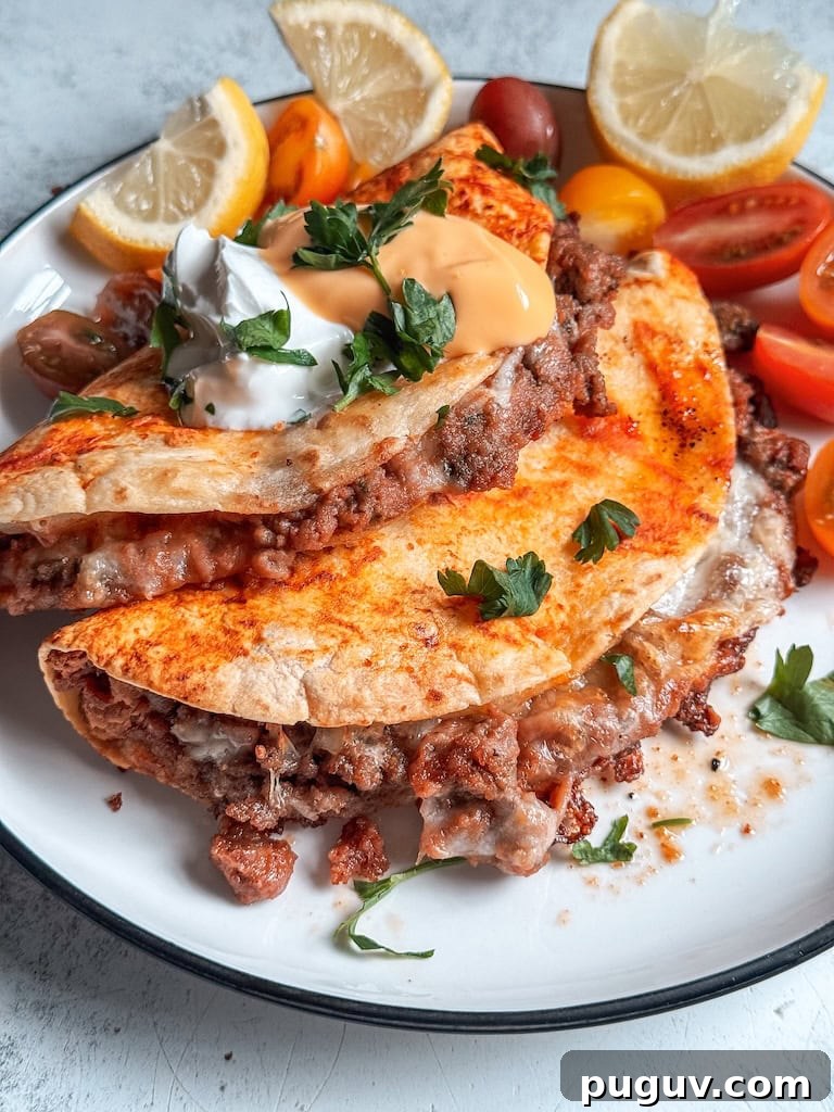 Baked beef and bean soft tacos with melted cheese and taco sauce