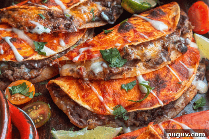 Baked beef and bean soft tacos with melted cheese and taco sauce