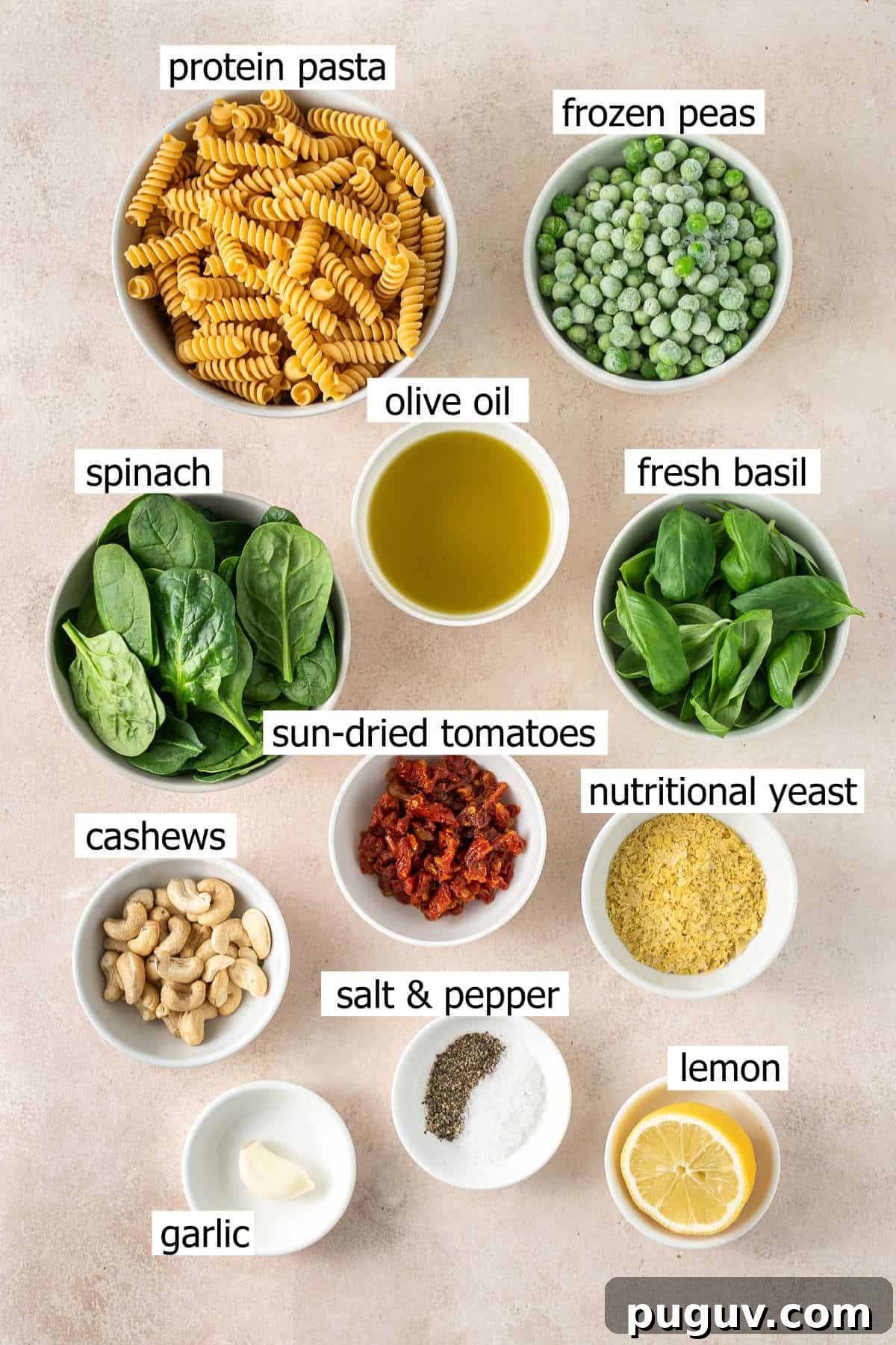 All ingredients needed to make high protein pea pesto pasta laid out in bowls.