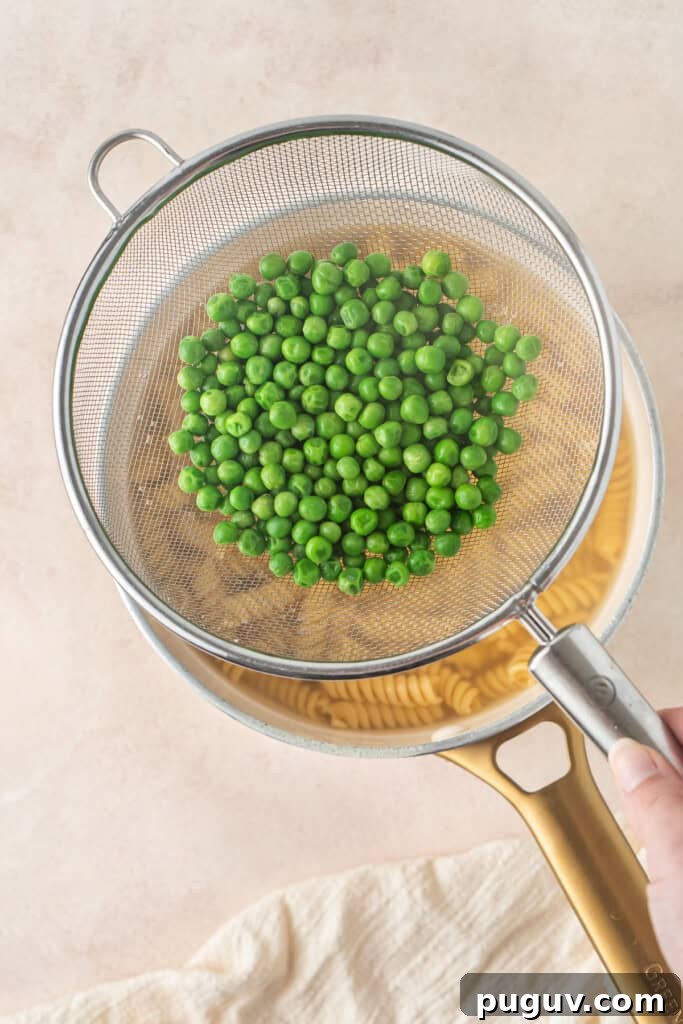 Cooking the pasta and the peas at the same time in a pot with a sieve. 