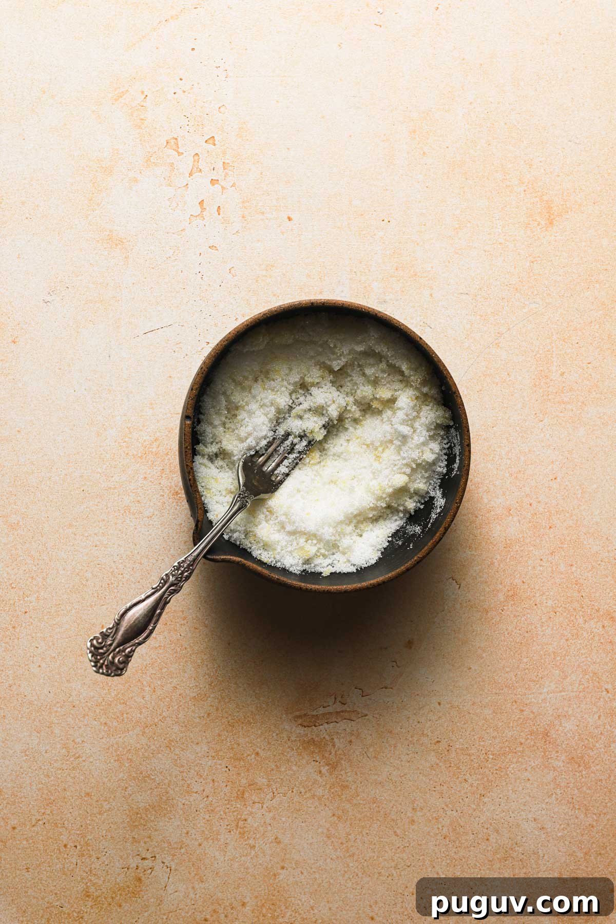 a bowl with sugar and a fork.
