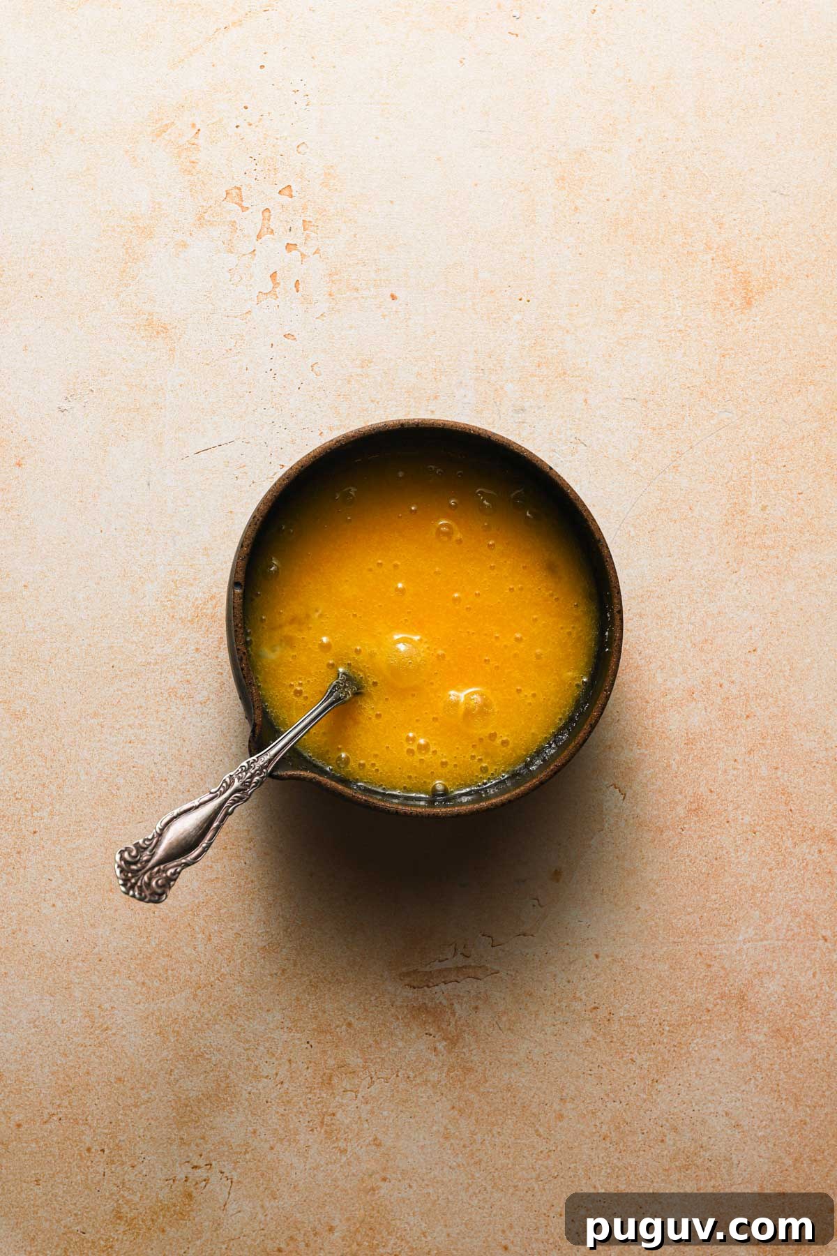 A bowl with a fork and egg-sugar mixture.