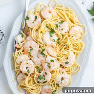 shrimp scampi on a platter over pasta
