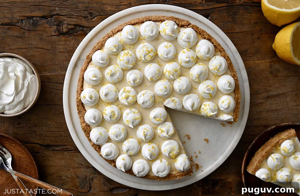 No-Bake Cheesecake Recipe: Creamy No-Bake Cheesecake Slice 6 Dollops of whipped cream atop a cheesecake with a graham cracker crust on a round serving plate.
